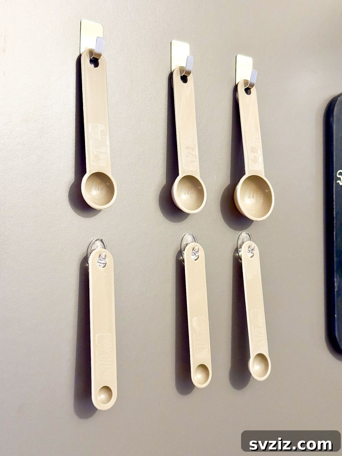 Hang Measuring Spoons with Command Hooks Inside the Cupboard