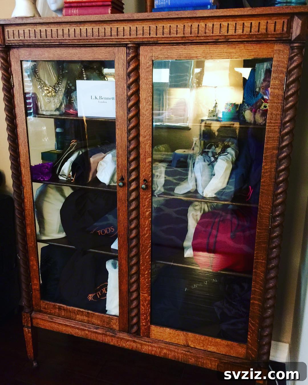 Antique glass cabinet displaying various purses