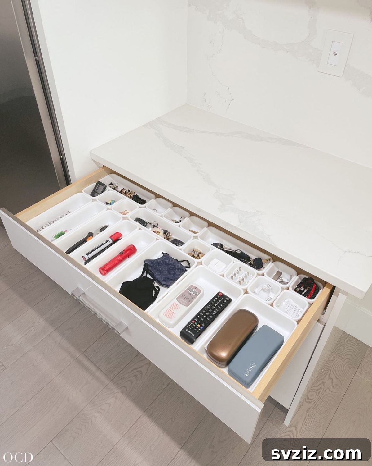27 Smart Solutions for Organizing Clutter 27 Categorized Drawer Organization - A meticulously organized drawer with small items grouped into clear compartments based on their categories, such as 'Office Supplies' or 'Small Tools.'