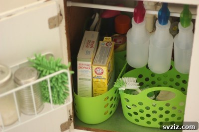 Under kitchen sink cabinet organized with plastic containers and a tension rod for hanging bottles
