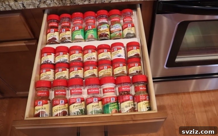 DIY tiered spice drawer organizer holding various spice jars
