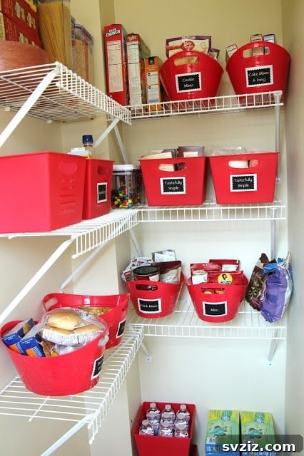 Vibrantly organized kitchen pantry with red plastic containers and chalkboard labels