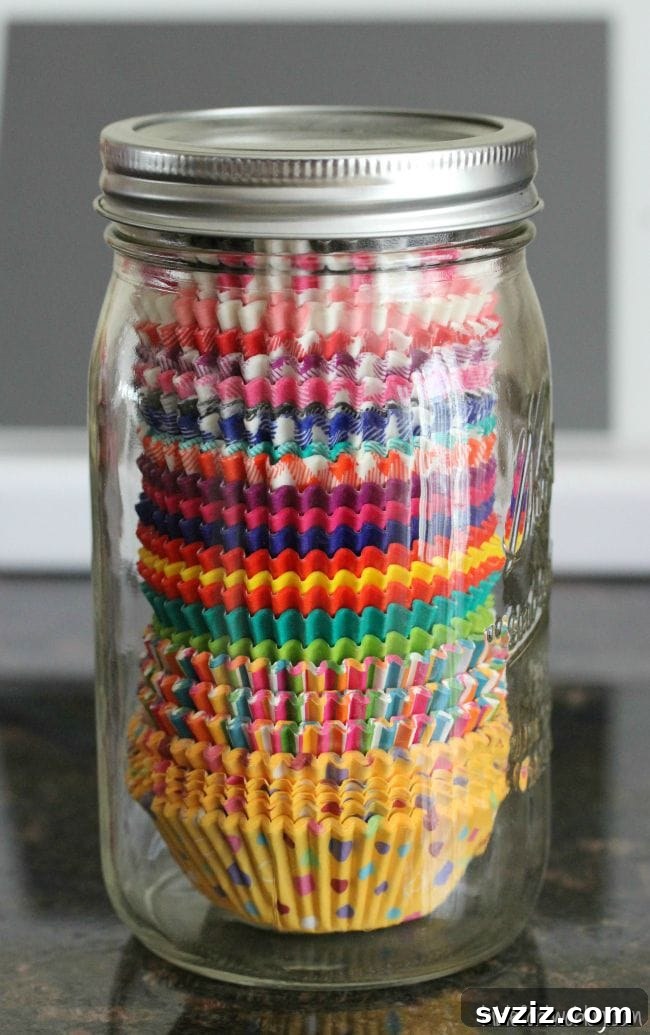 Colorful cupcake liners neatly stacked inside a clear mason jar