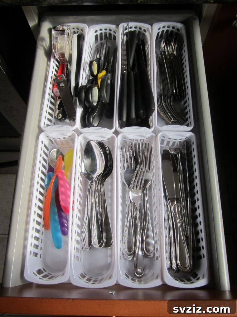 Organized kitchen cutlery drawer using small plastic Dollar Tree baskets as dividers