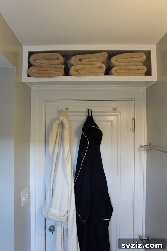 Bathroom linen storage shelf above door