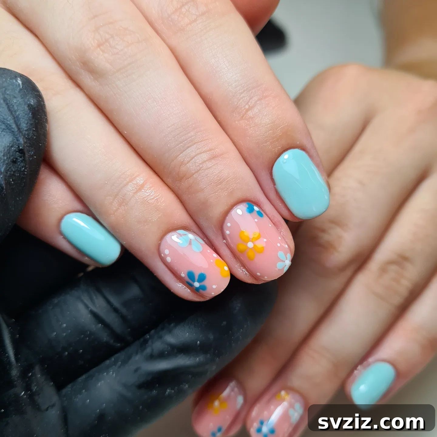 Pink and blue floral nail art on short nails