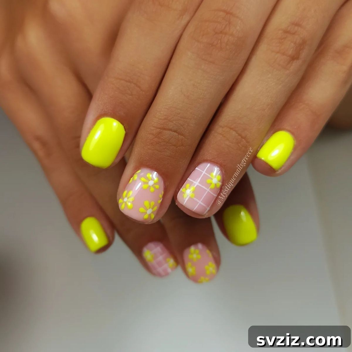 Bright yellow and pink floral nail art on short nails