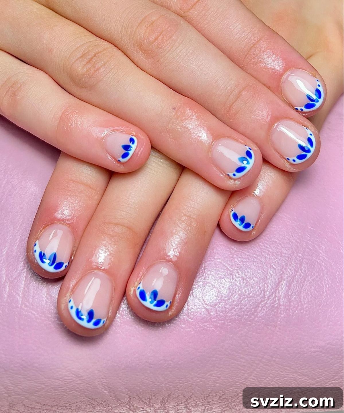 Blue and white nail art design on short nails, focused on tips