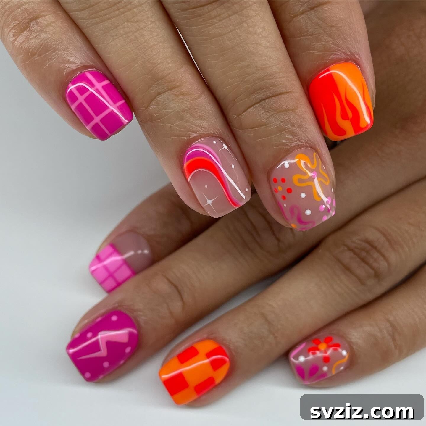 Abstract modern nail art with warm orange and lilac tones on short nails