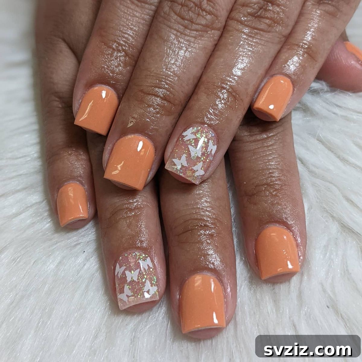Glitter butterfly nail art on apricot-colored short nails