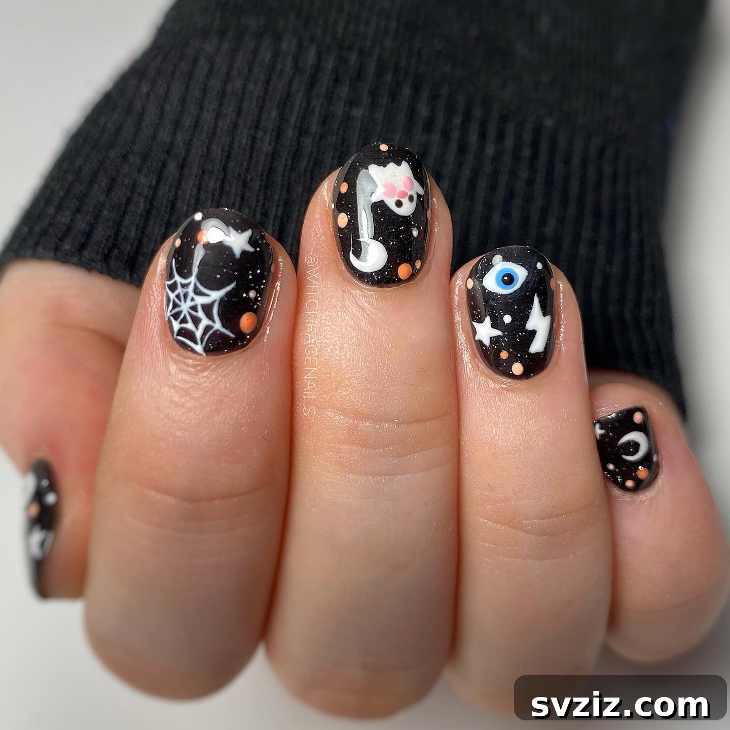 Spooky Halloween themed nail art with ghosts, spiderwebs, and evil eyes on black nails