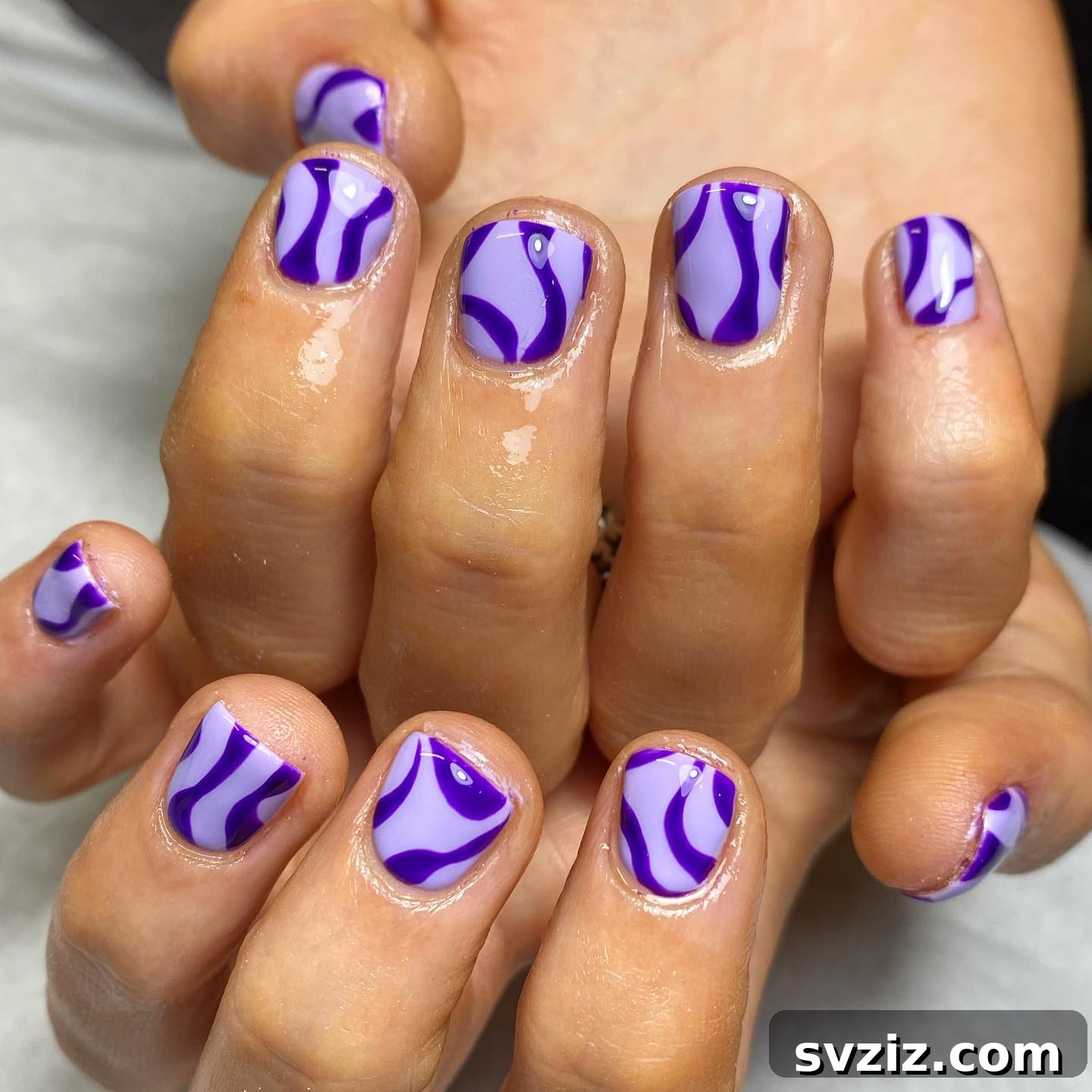 Dramatic purple swirl nail art on short nails