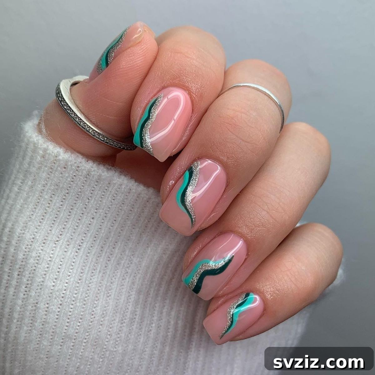 Minimalist green swirl nail art on a blush pink base for short nails
