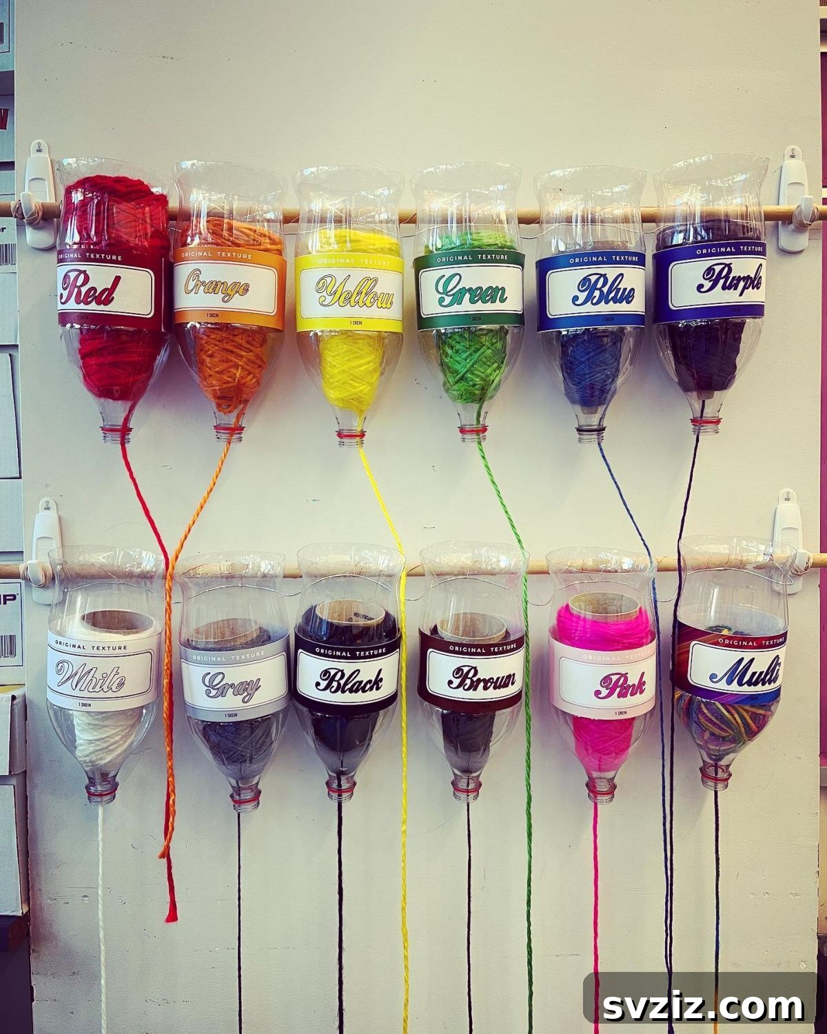 Unlock Creativity: Smart Organization for Your Art Studio 4 DIY yarn dispensers made from recycled soda bottles, providing an eco-friendly and practical storage solution for string and yarn in an art room. Hung on the wall, they offer easy access and prevent tangles, making them ideal for classrooms.