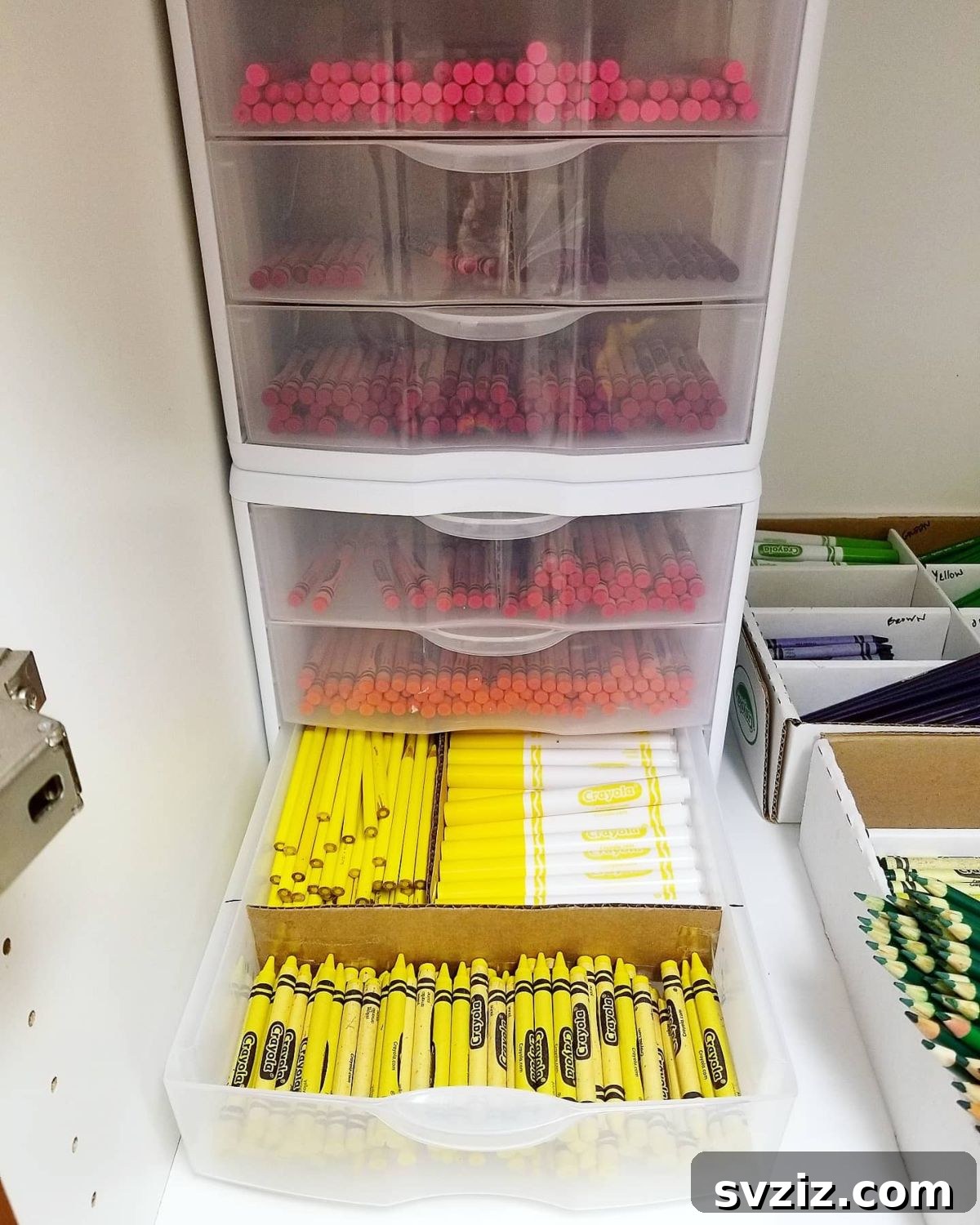 Unlock Creativity: Smart Organization for Your Art Studio 7 Color-coded crayon storage in an art room, featuring organized bins of crayons and markers separated by color. This system makes it easy for students to find specific shades, promotes tidiness, and adds a vibrant aesthetic to the creative space.
