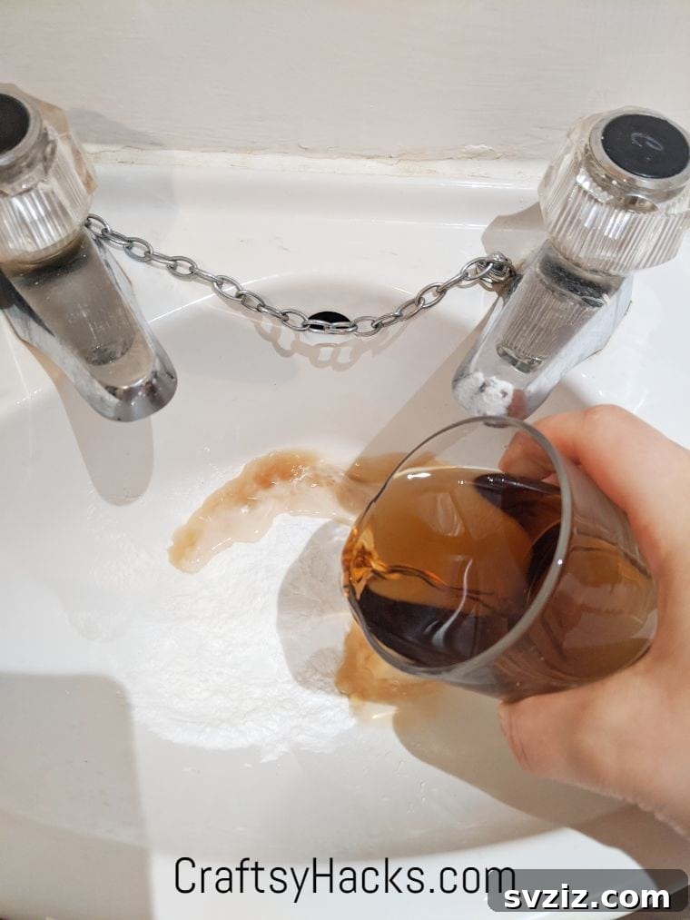 Clearing a clogged drain using baking soda and vinegar, a natural alternative