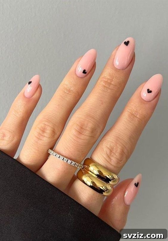 41 Effortless Nude Nail Ideas for Everyone 27 Charming nude nails featuring dainty small heart designs, easily recreated with stickers for an adorable look.