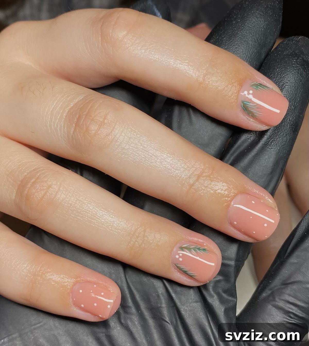 41 Effortless Nude Nail Ideas for Everyone 32 Playful and festive Christmas nude manicure with polka dots, trees, and other fun holiday elements.