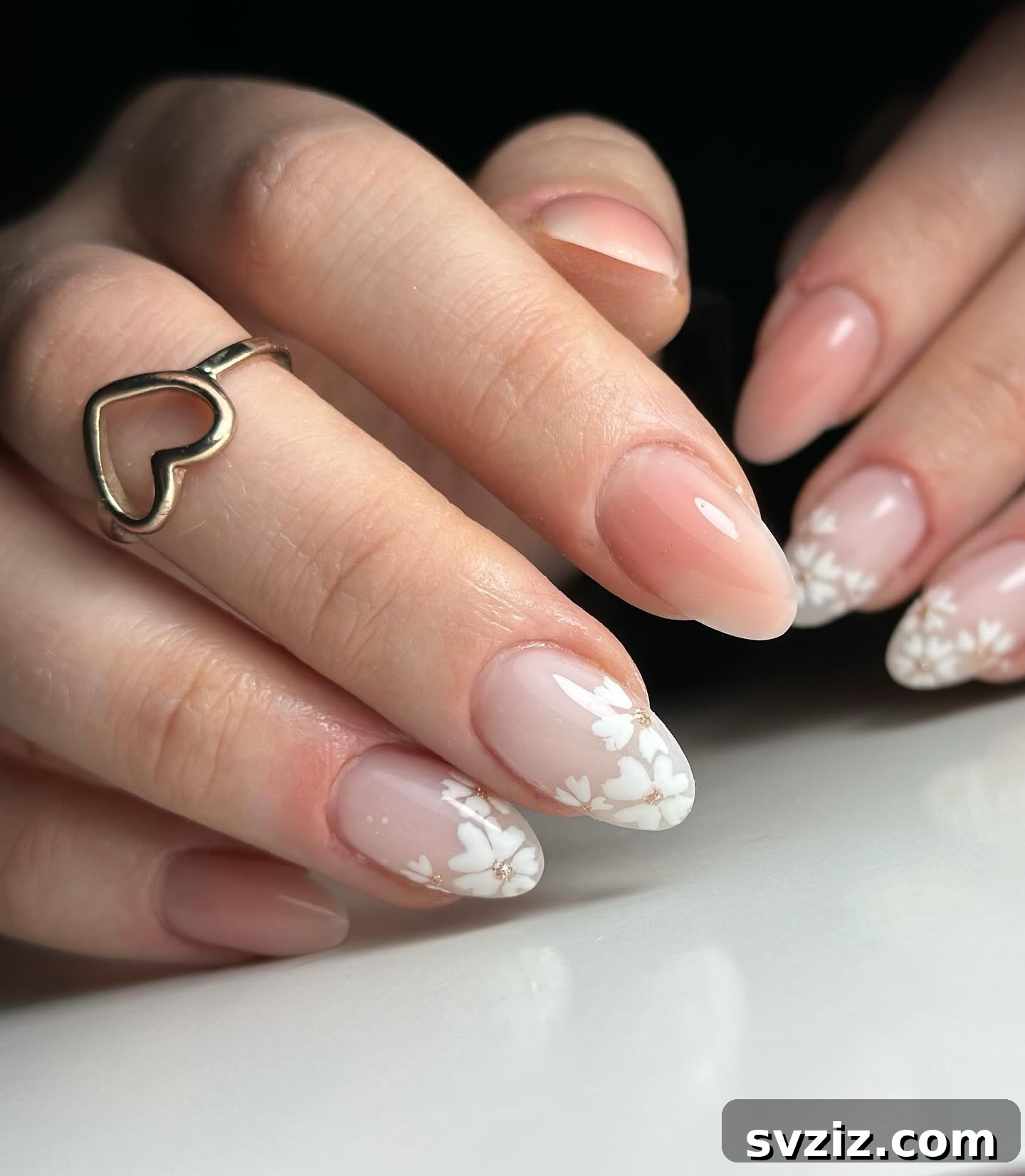 41 Effortless Nude Nail Ideas for Everyone 36 Gorgeous nude nails adorned with delicate white floral designs on the tips, ideal for weddings or springtime.