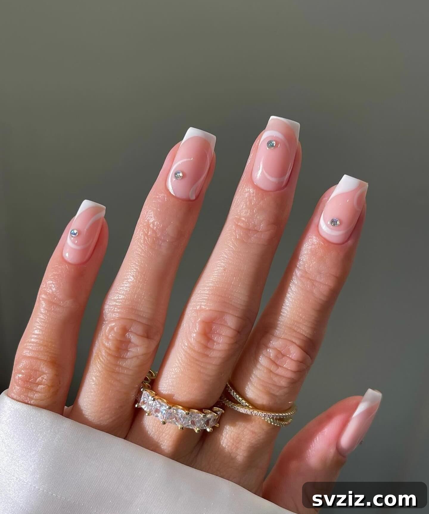 41 Effortless Nude Nail Ideas for Everyone 41 Luxurious swirly nude nails adorned with diamonds, blending elegant white swirls with sparkling rhinestones for ultimate glamor.