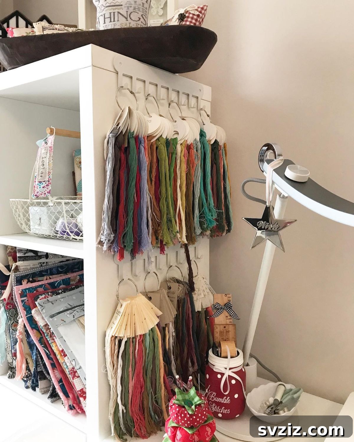 Embroidery floss organized on wall-mounted hooks, showcasing a rainbow of colors.