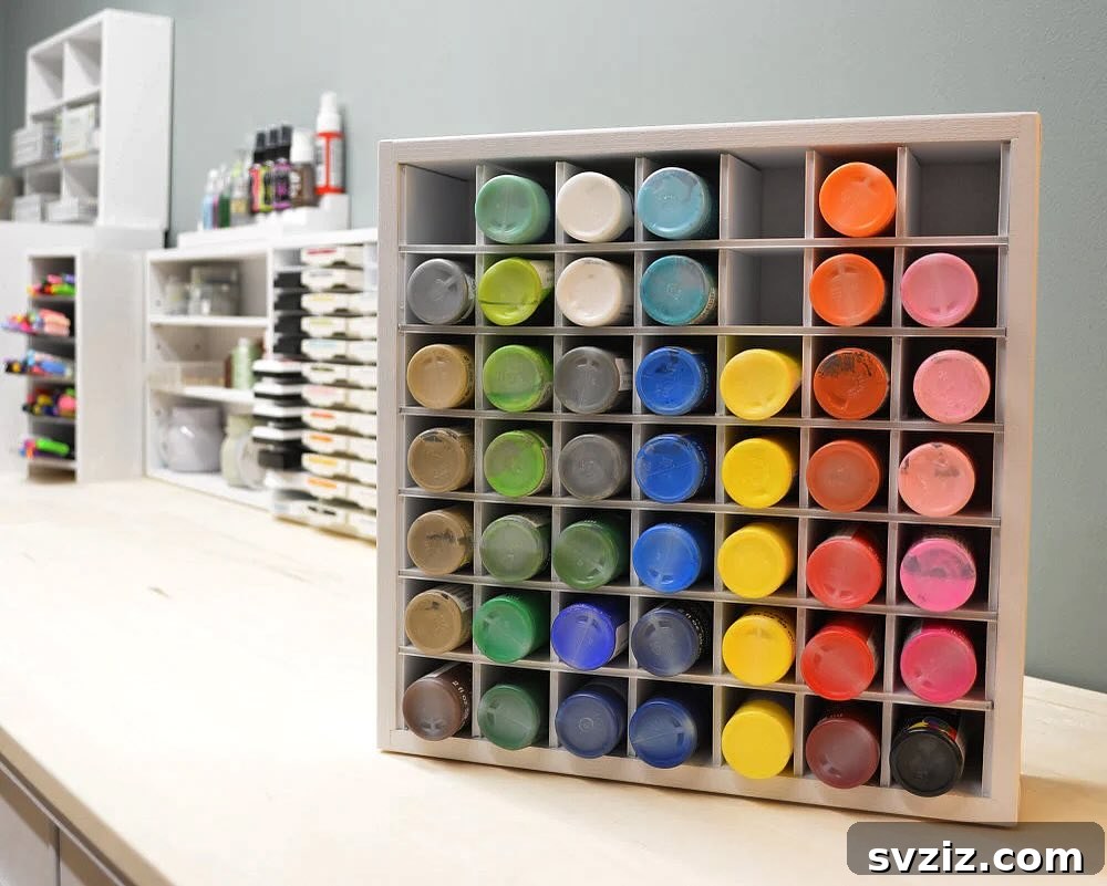 Craft paint organizer with individual cubbies, showcasing neatly arranged paint bottles.
