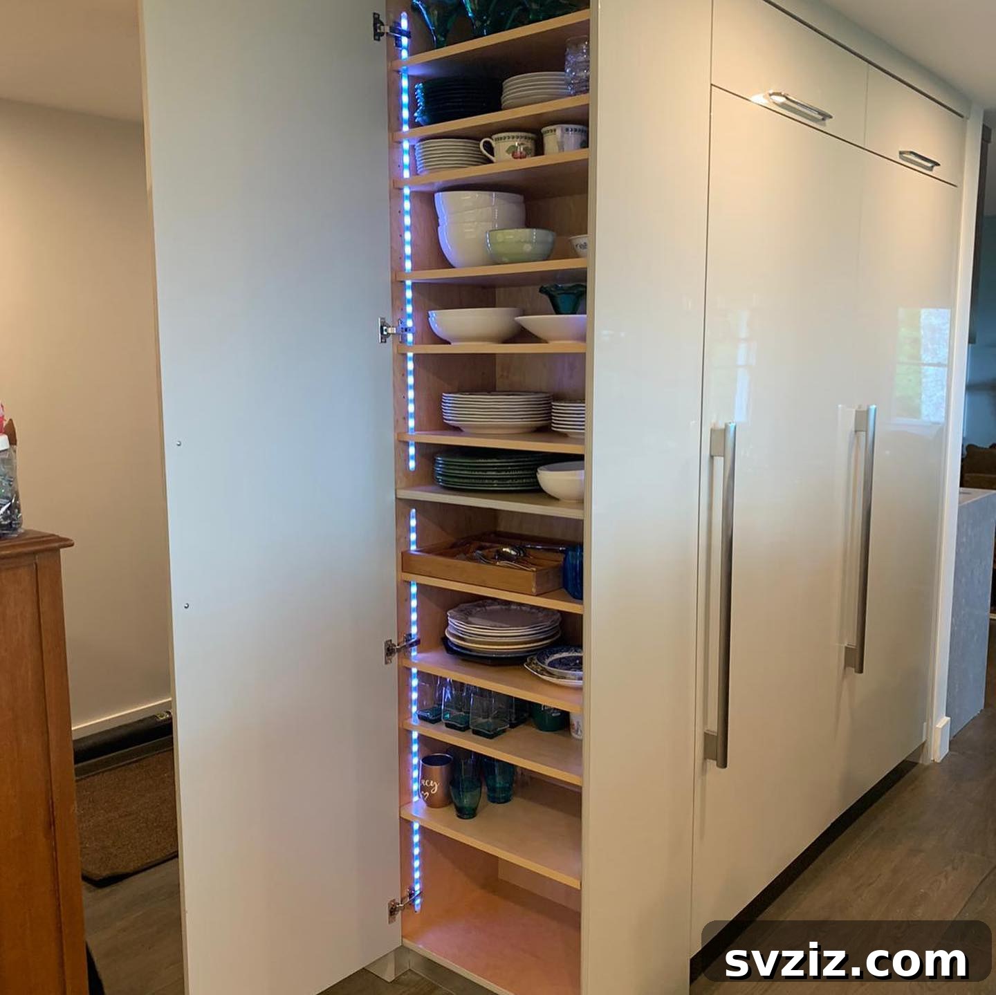 Smart Plate Organization Ideas for a Perfectly Tidy Kitchen 17 Kitchen cabinet with under-shelf LED lighting illuminating stacked plates and dishes, enhancing visibility and ambiance.