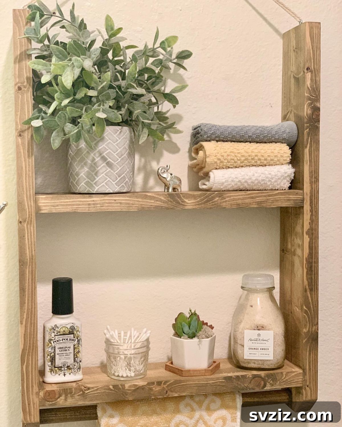 21 Smart Ways to Utilize the Space Above Your Toilet 4 Bathroom shelf above toilet with a dowel rod for hanging a towel.