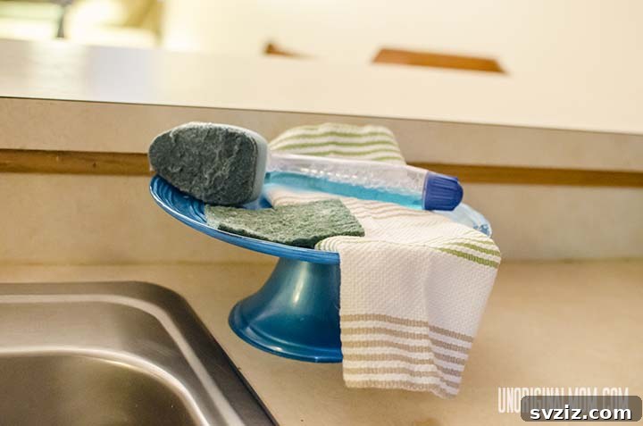 13 Genius Ways to Organize Your Sink Area 7 Decorative cake stand serving as a soap holder with various cleaning tools, a unique kitchen sink organization idea.
