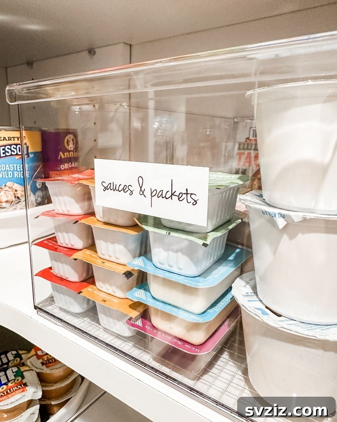 Clear pantry bins organizing various condiments