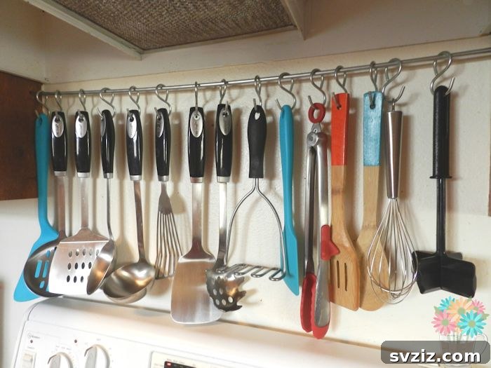17 Smart Utensil Organizing Hacks 11 Rustic DIY hanging utensil rack above a kitchen stove, displaying spatulas, ladles, and whisks