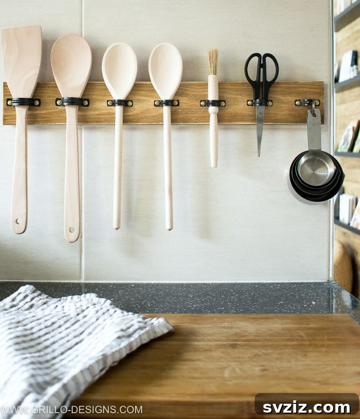 17 Smart Utensil Organizing Hacks 13 Rustic DIY utensil rack made with a wooden board and plumbing pipe clips, perfect for farmhouse kitchen decor
