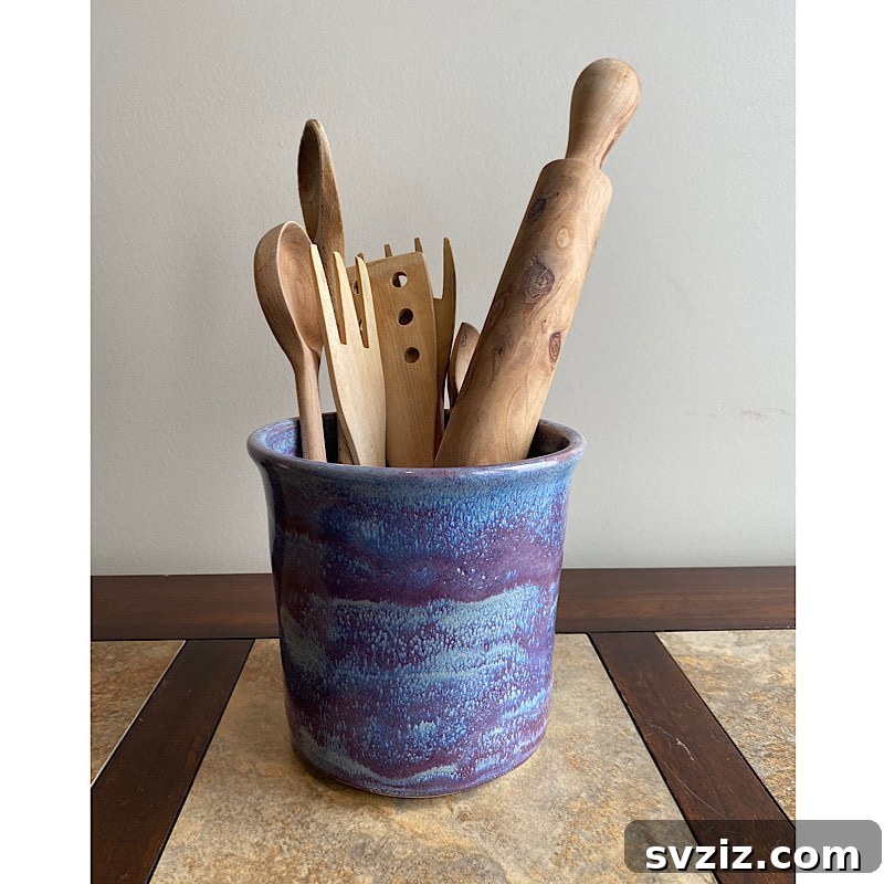 17 Smart Utensil Organizing Hacks 18 Vibrant ceramic pottery utensil holder adding a decorative pop of color to a neutral kitchen countertop