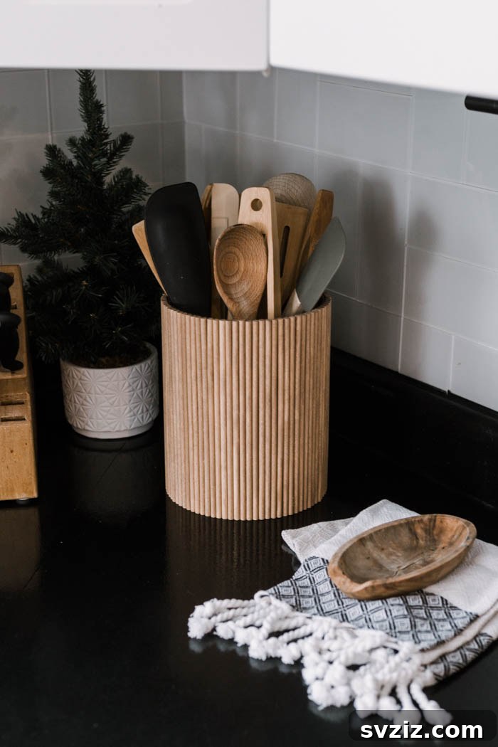 17 Smart Utensil Organizing Hacks 10 Elegant fluted DIY utensil holder made from a glass vase and wooden dowels, perfect for modern kitchen decor