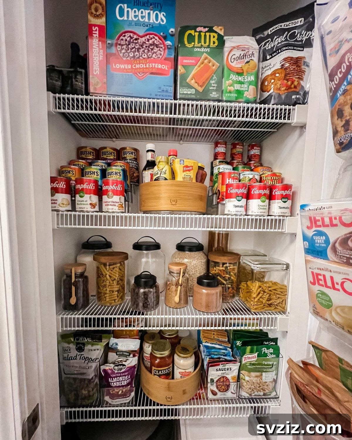 Tiered step shelves holding various canned goods and jars in an organized pantry.