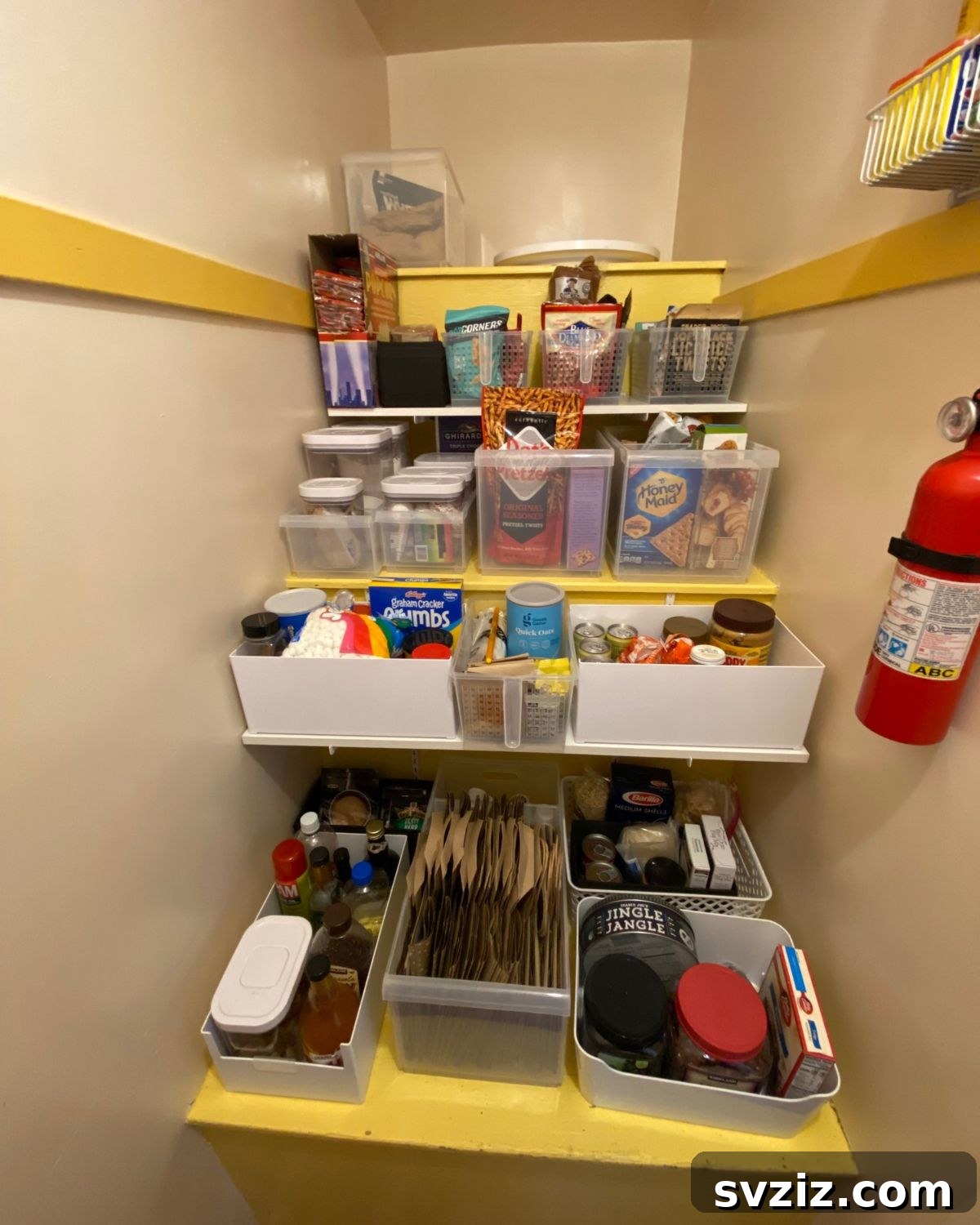 Deep storage bins neatly arranged in a pantry, holding various categorized food items.