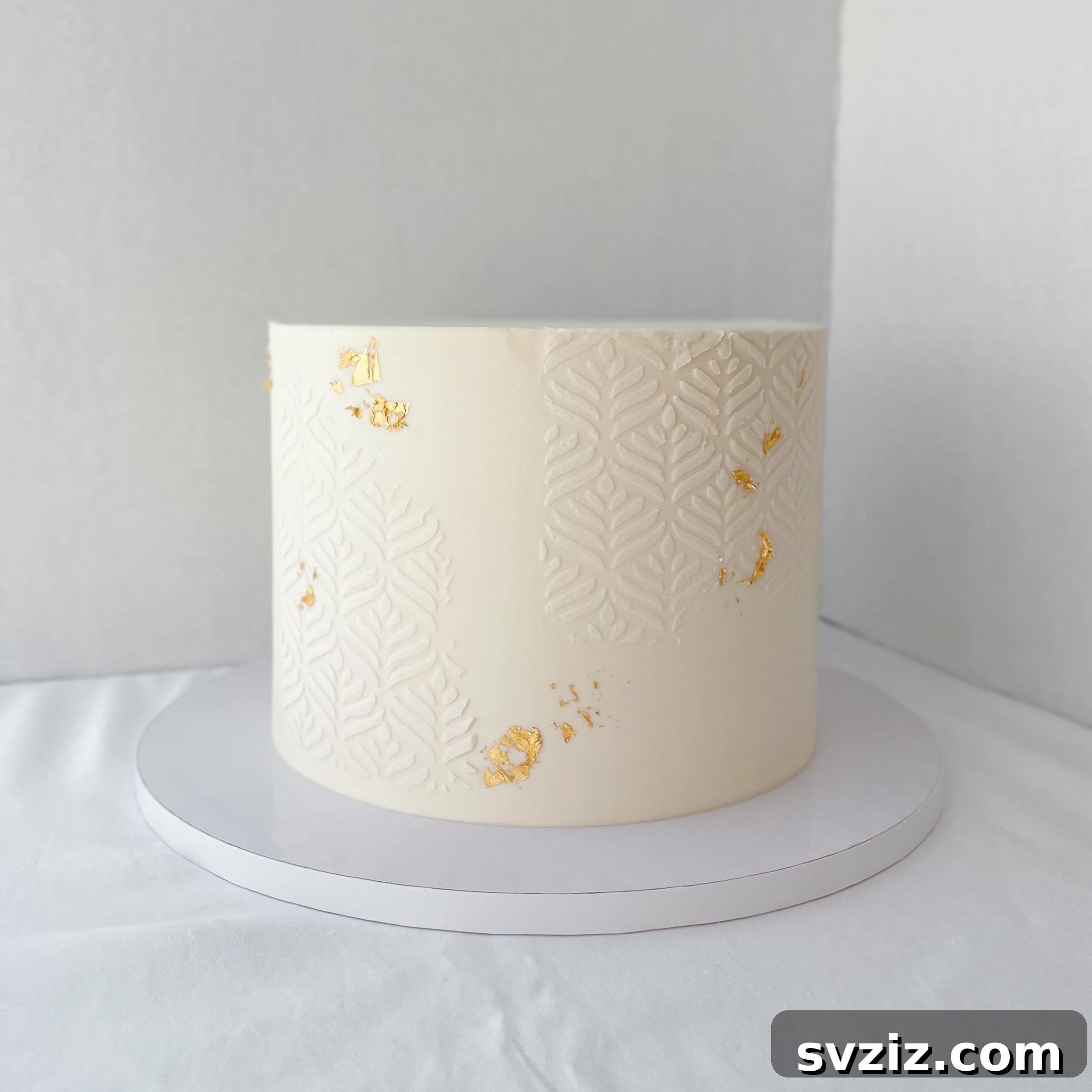 27 Elegant Wedding Cake Inspirations 17 A simple yet elegant wedding cake with a sophisticated stenciled pattern and delicate edible gold leaf accents, hiding a tempting chocolate cake filling, perfect for a refined celebration.