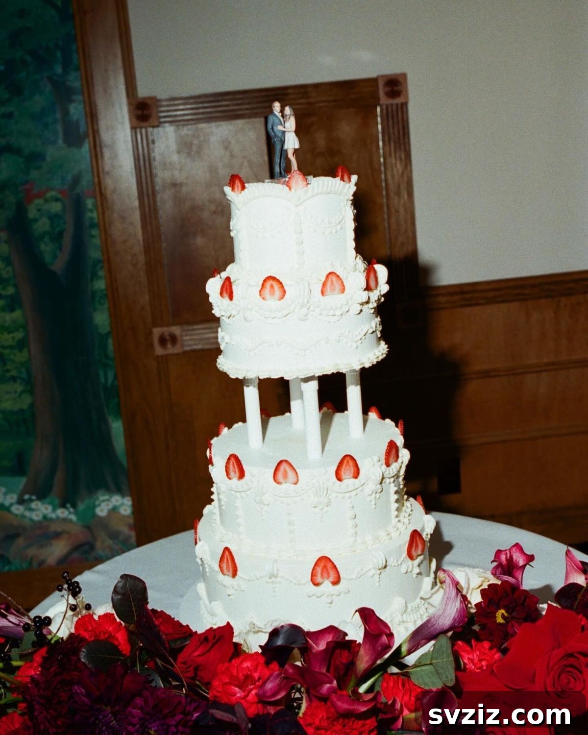27 Elegant Wedding Cake Inspirations 19 A dreamy wedding cake featuring a romantic strawberries and cream theme, topped with a bride and groom cake topper gazing into each other's eyes, symbolizing a lifetime of shared dreams.