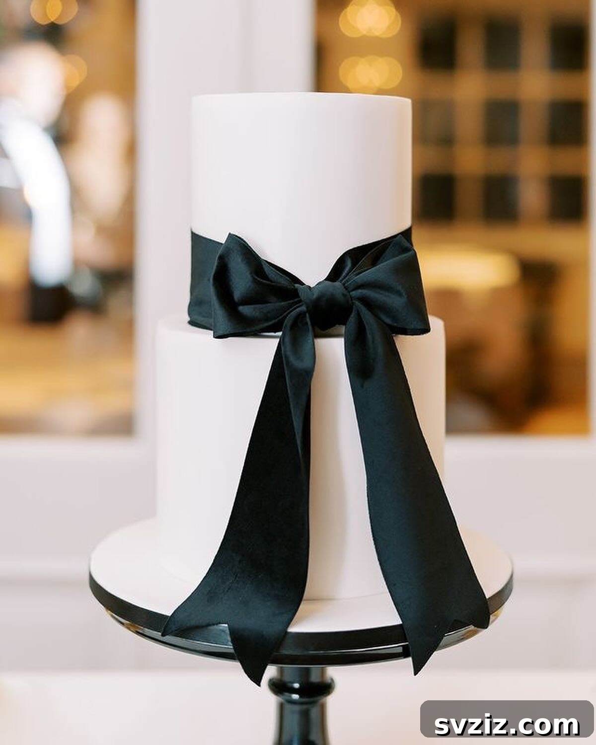 27 Elegant Wedding Cake Inspirations 20 A chic monochrome wedding cake featuring a decadent black ribbon bow, creating a masterpiece of contrast and a bold statement of beauty, perfect for a sophisticated celebration.