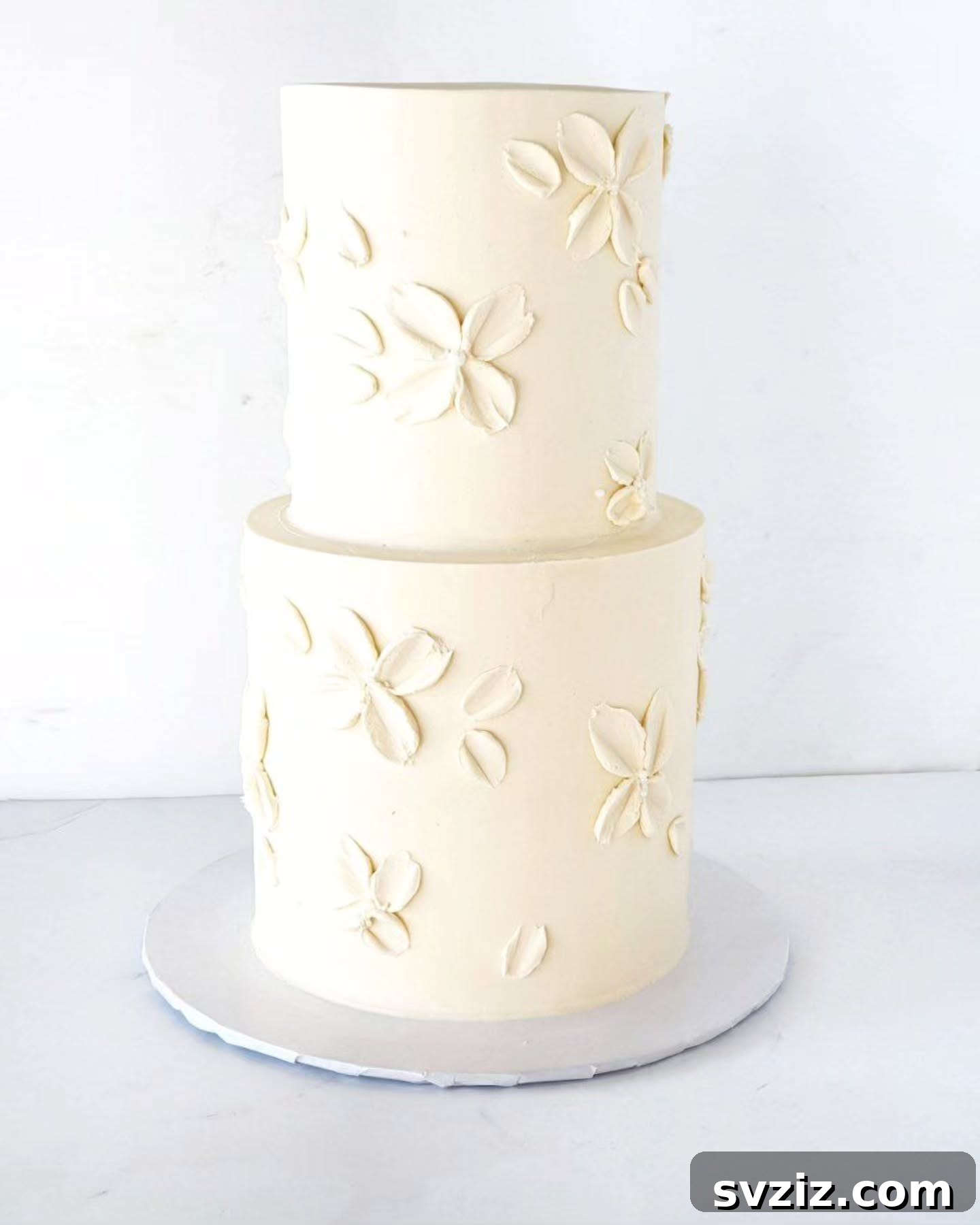 27 Elegant Wedding Cake Inspirations 7 A two-tier minimalist wedding cake design adorned with sweet, carefree white flowers, proving that understated elegance can leave the biggest, most striking impression on your wedding day.