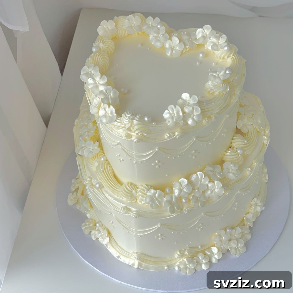 27 Elegant Wedding Cake Inspirations 10 An ethereal and enchanting two-heart wedding cake design, symbolizing everlasting love, adorned with pearly accents, tiny piped flowers, and delicate swirls, reminiscent of a fairytale dream.