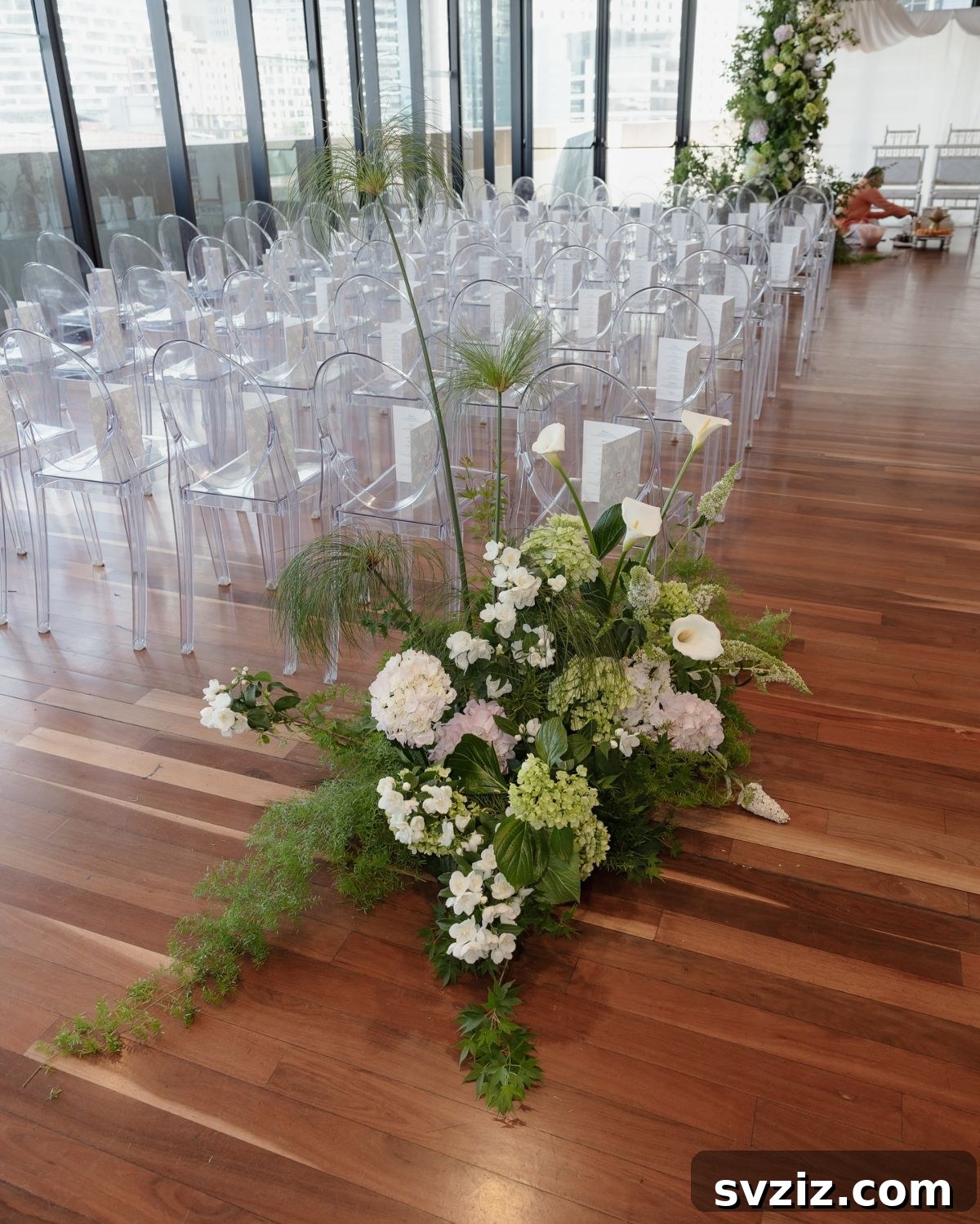 Modern classic wedding reception table with crystal clear lucite chairs and white floral centerpieces.