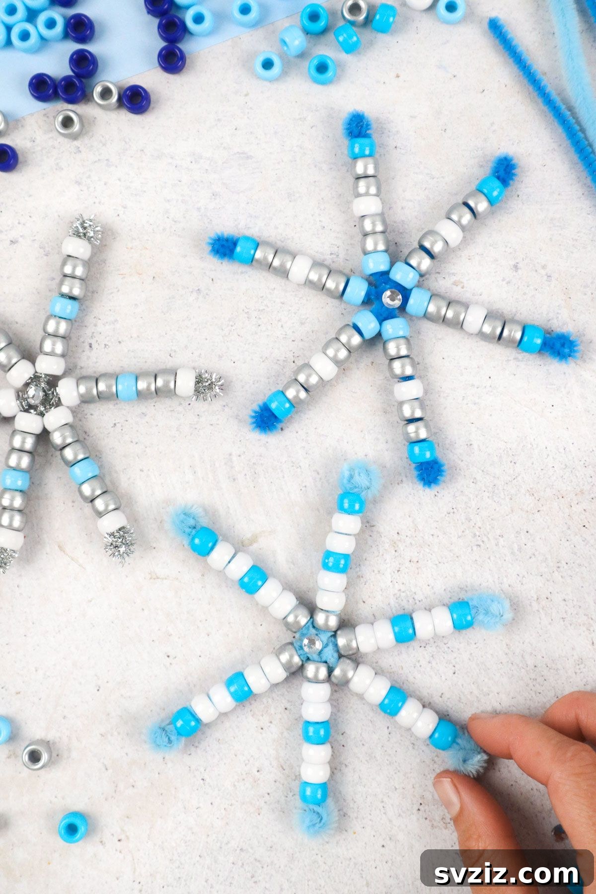 31 Effortless Kids Crafts for Hours of Fun 5 Elegant Pipe Cleaner Snowflakes adorned with pony beads and rhinestones, a perfect craft for developing fine motor skills.