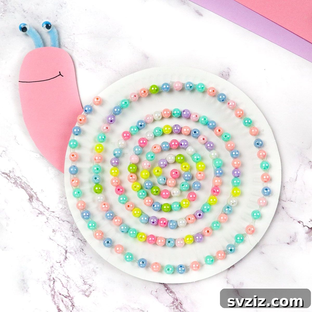 31 Effortless Kids Crafts for Hours of Fun 9 Beautiful Paper Plate Snails adorned with colorful beads, a customizable craft for children.