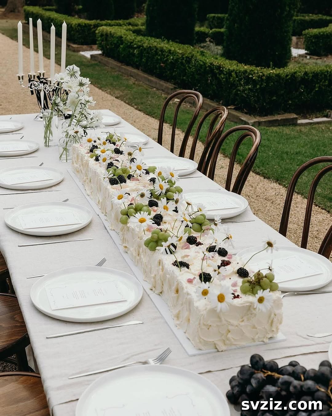 Exquisite Wedding Dessert Spreads 18 A breathtakingly long wedding cake serving as both centerpiece and dessert, adorned with fresh flowers, offering a unique and memorable guest experience.