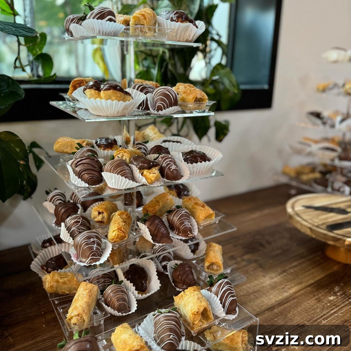 Exquisite Wedding Dessert Spreads 8 A stunning pastry tower showcasing a beautiful arrangement of Baklava rolls, eclairs, and chocolate-covered strawberries, perfect for an elaborate dessert table.