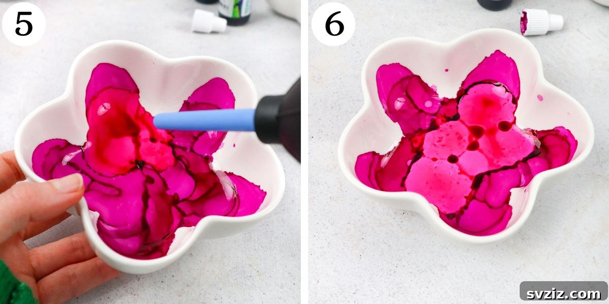 Adding more alcohol ink drops to deepen colors and layer designs