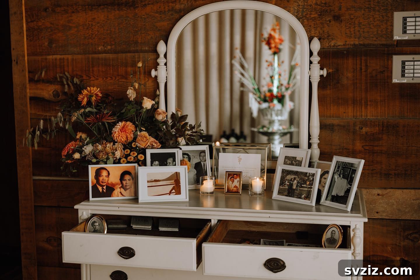 Dresser filled with framed photos and open drawers showcasing additional pictures for a wedding memory display.