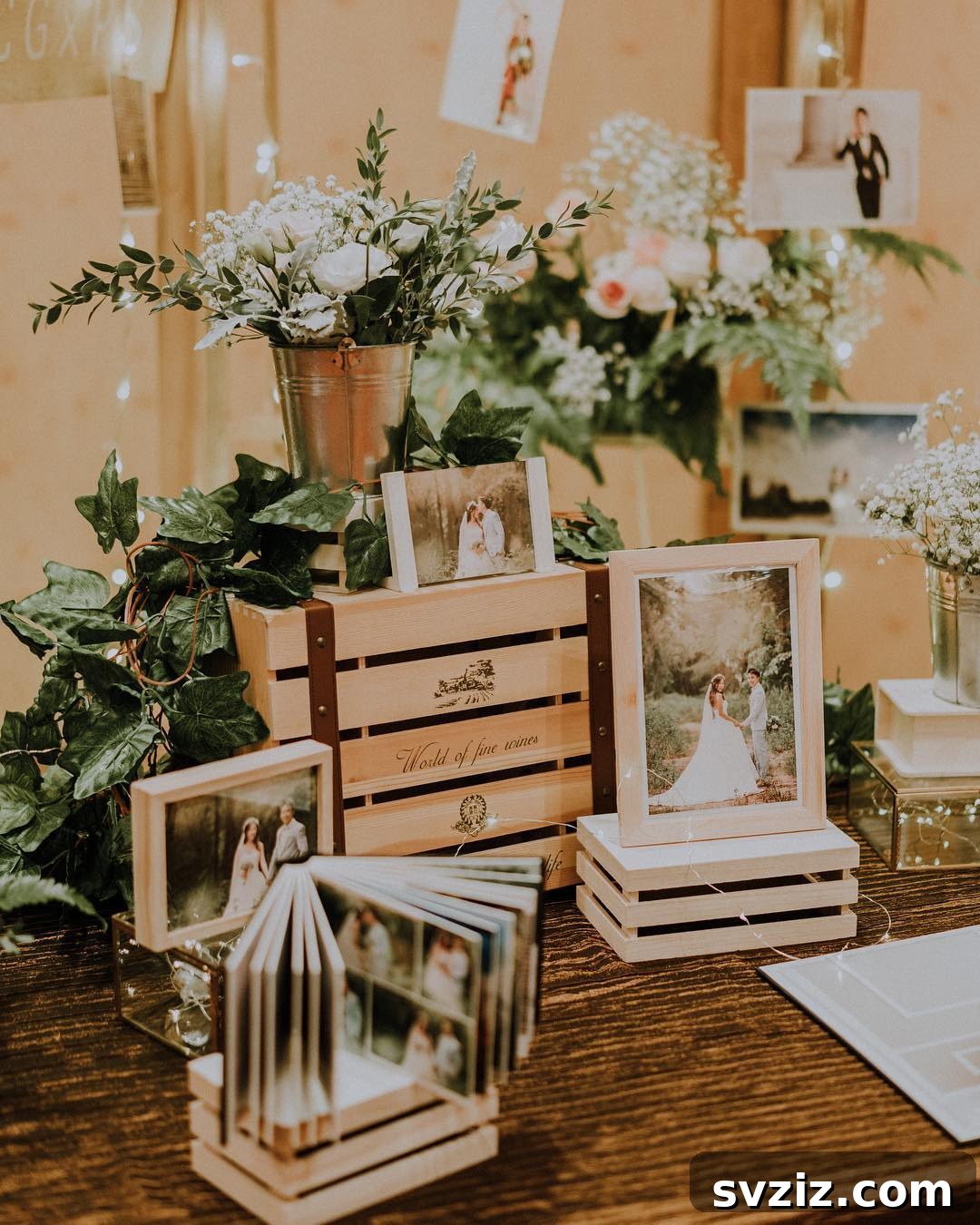 Rustic wedding memory table featuring wooden frames, tin cans, greenery, and a photo album.
