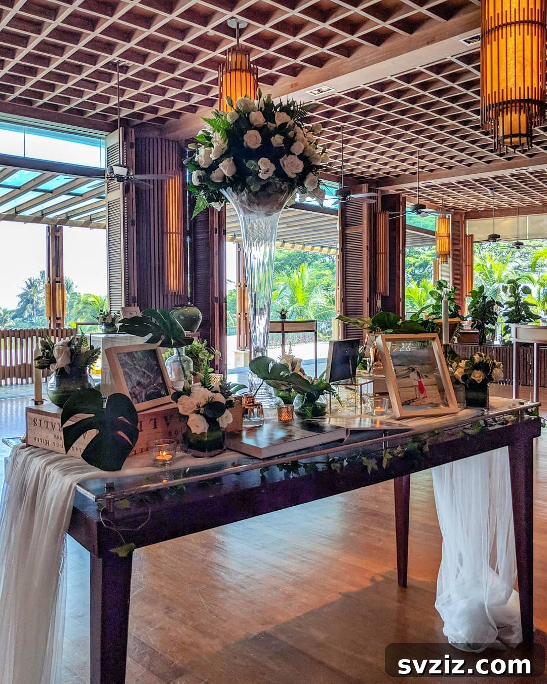 Wedding memory table designed for viewing from both sides, filled with framed photos and flowers.